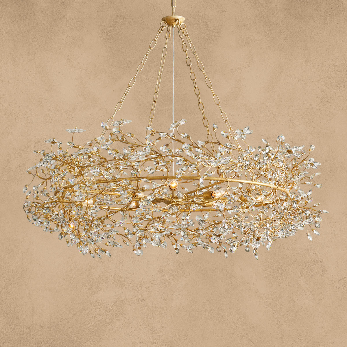 Faverelle chandelier in gold with crystal blossoms, illuminated