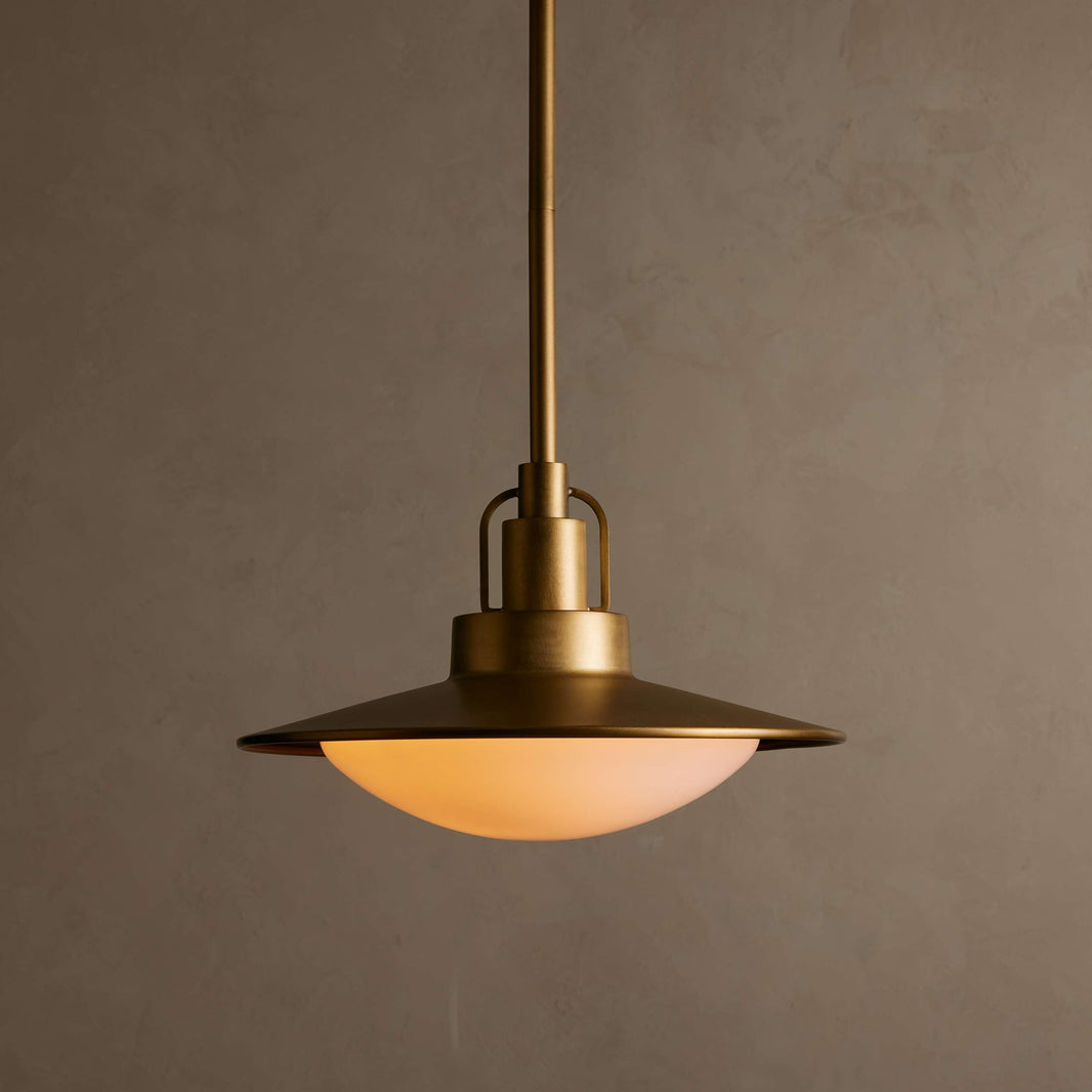 Bronze pendant light with a warm glow against a brown background