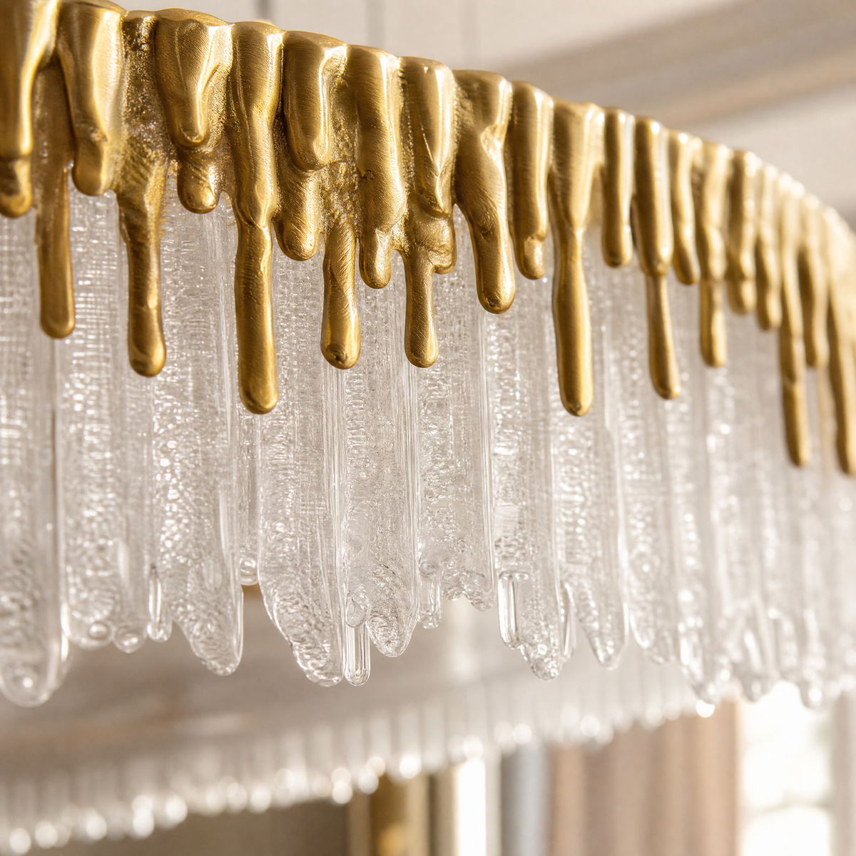 A double-tier chandelier with icicle-style textured crystal drops and a satin warm gold metal band.