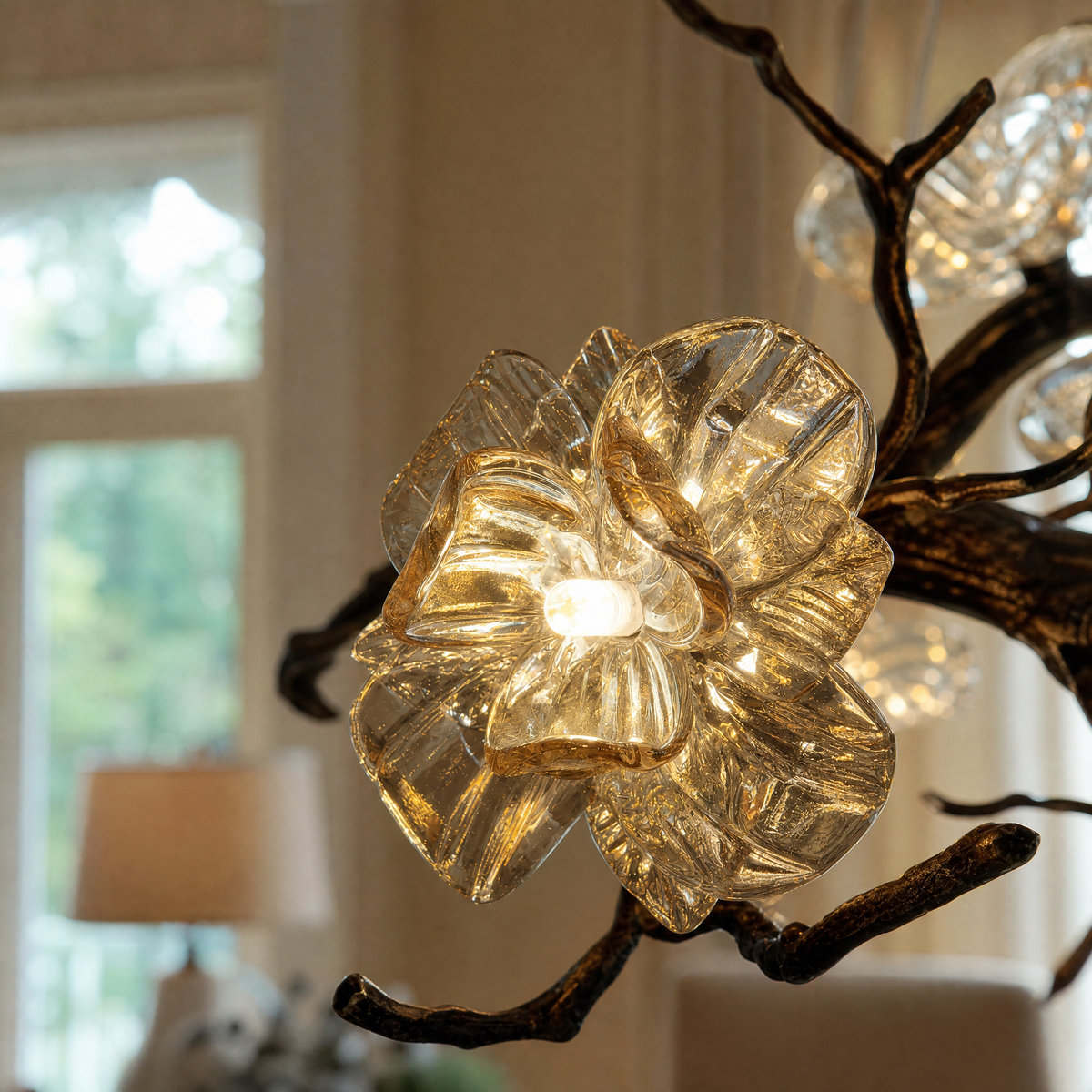 An antique brass chandelier with branching arms and frosted glass blossom shades suspended by cables.