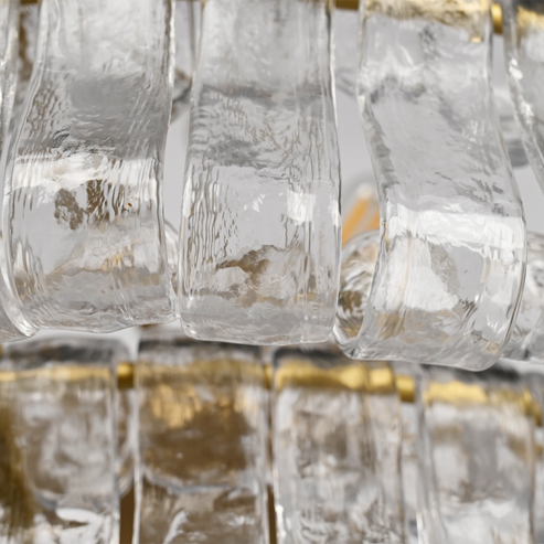 Givrelle round chandelier macro of clear textured ice glass around a warm bulb